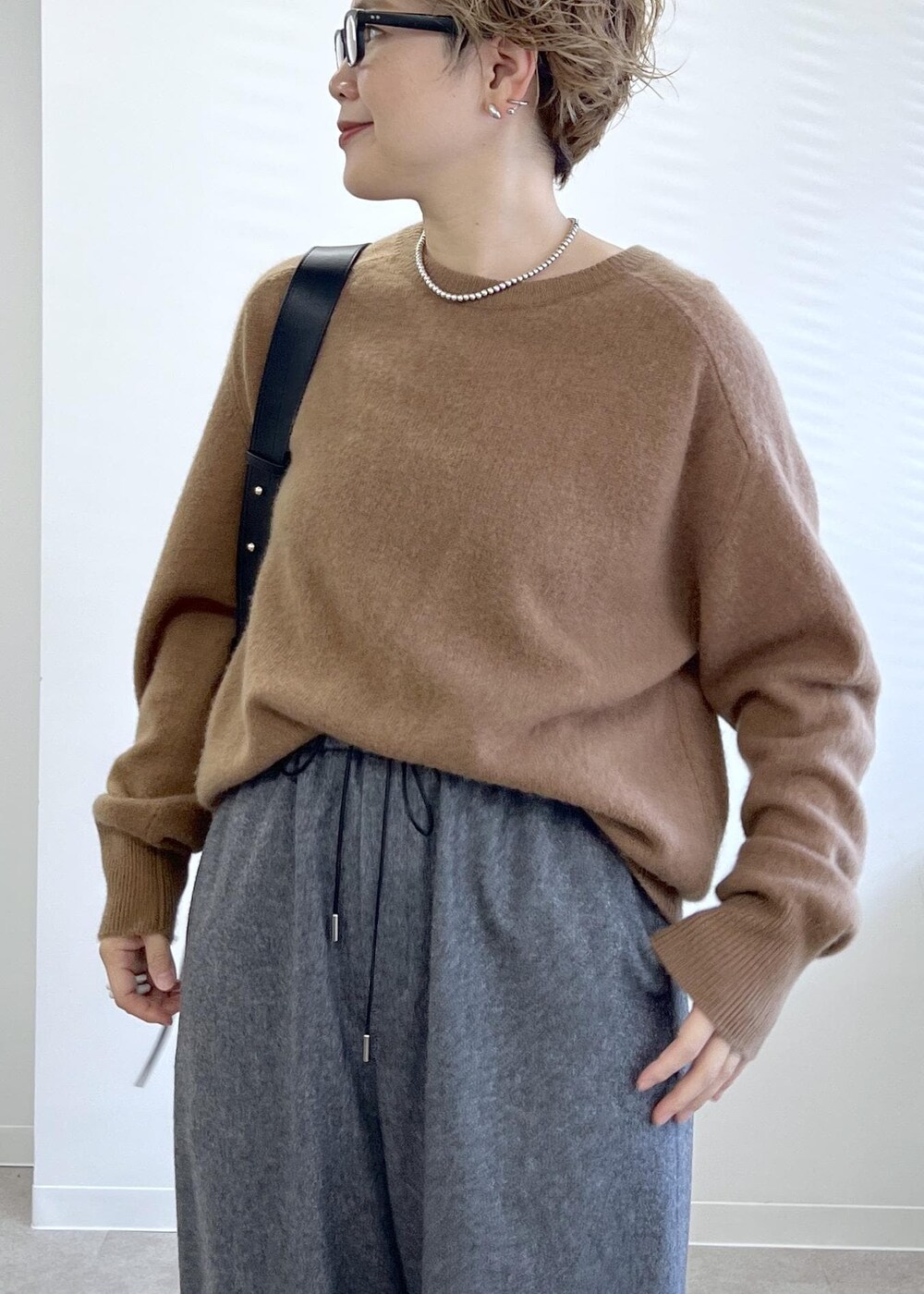 ブラック系のショルダーバッグ、グレー系のその他パンツ、ブラウン系のニット/セーターを着用したレディースの秋コーディネートの6枚目の写真