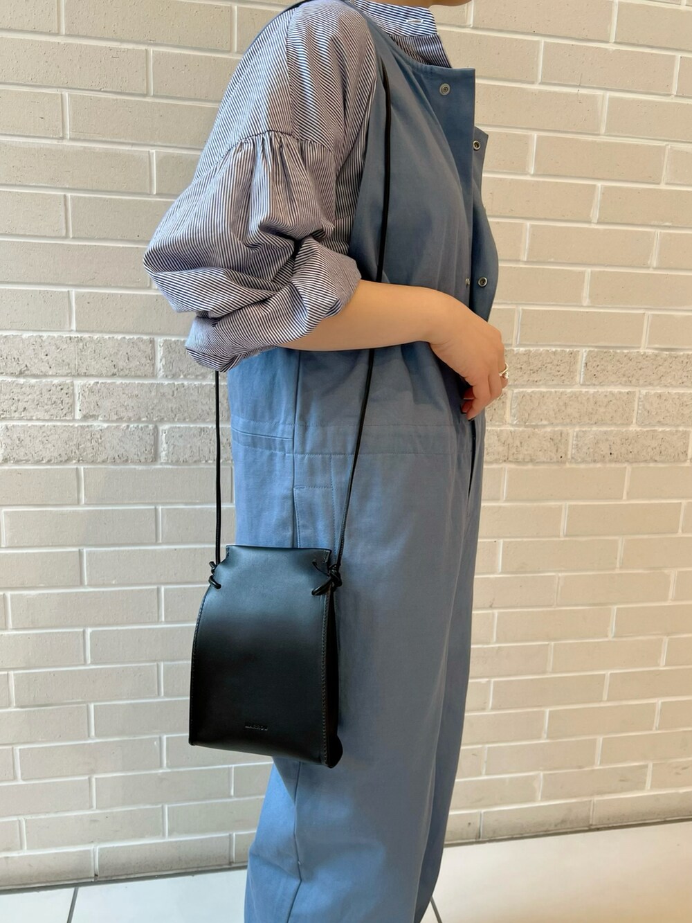 ベージュ系のつなぎ/オールインワン、ブルー系のシャツ/ブラウス、ブラック系のサンダルを着用したレディースの春コーディネートの5枚目の写真