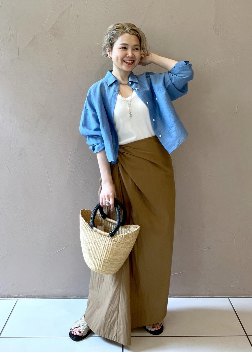 ゴールド系のサンダル、ブラウン系のスカート、ブルー系のシャツ/ブラウスを着用したレディースの夏コーディネートの2枚目の写真