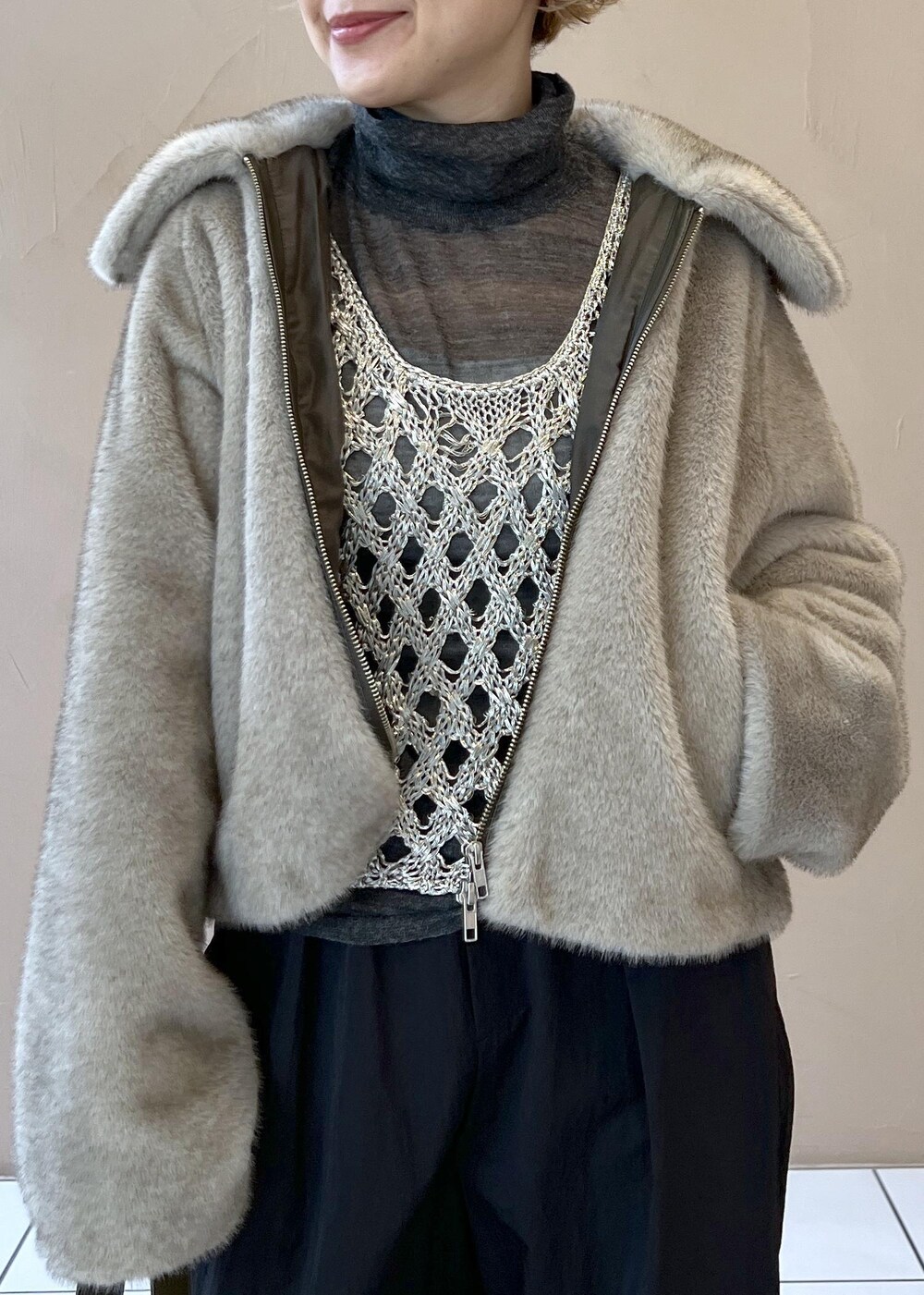 シルバー系のベスト、グレー系のブルゾン、グレー系のニット/セーターを着用したレディースの秋コーディネートの5枚目の写真