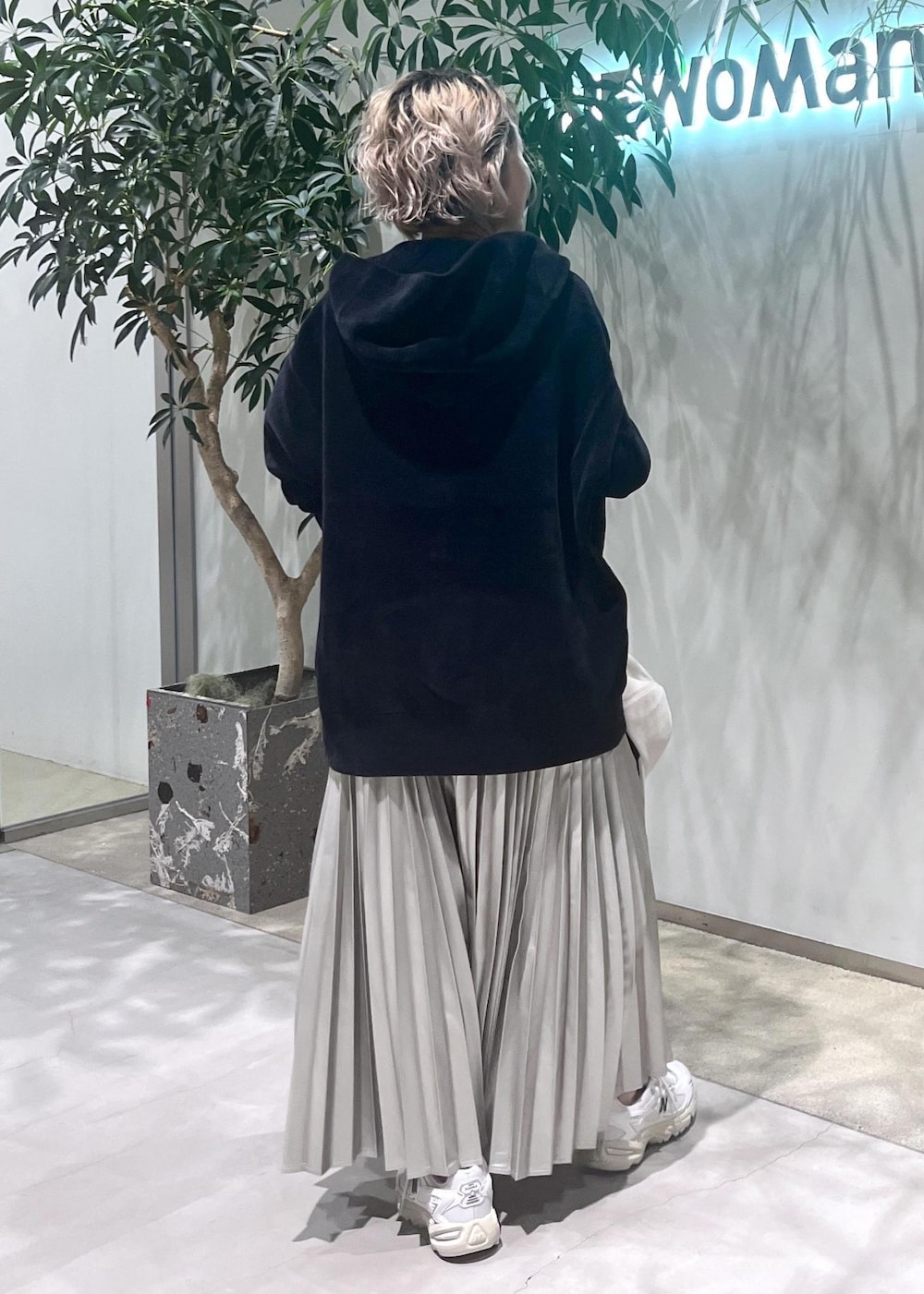 ベージュ系のスカート、ブラック系のタンクトップ、ブラック系のパーカーを着用したレディースの秋コーディネートの6枚目の写真