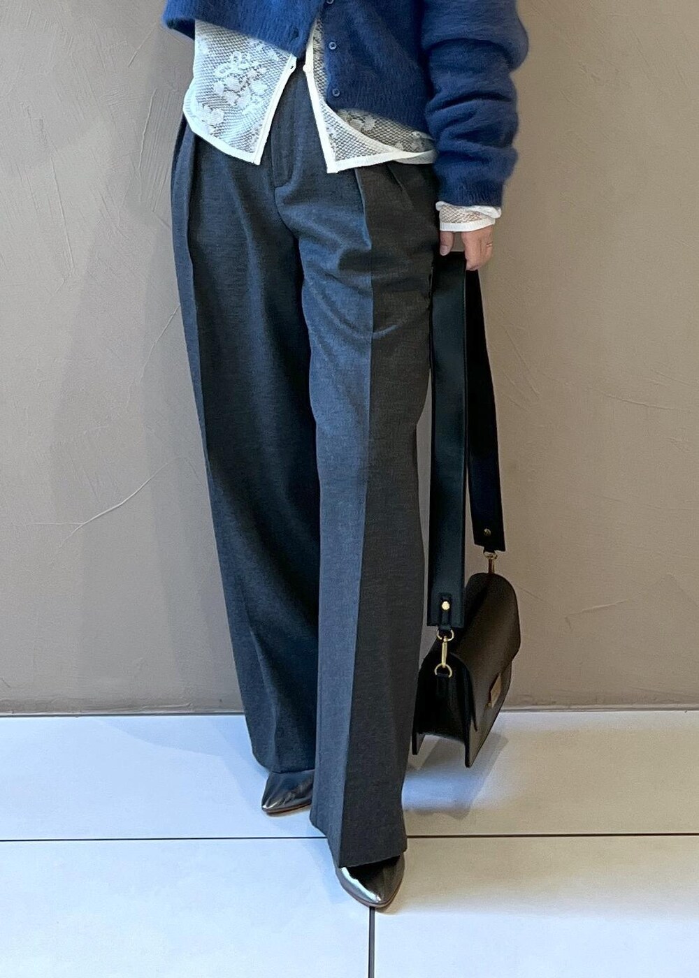 ブラック系のショルダーバッグ、ブルー系のカーディガン/ボレロ、グレー系のスラックスを着用したレディースの冬コーディネートの10枚目の写真