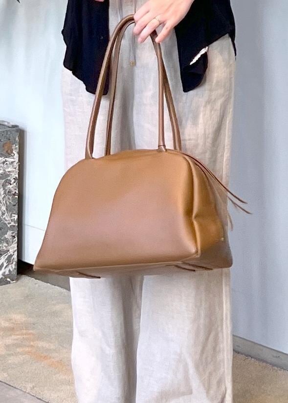 ブラウン系のボストンバッグ、ホワイト系のその他パンツ、ブラック系のサンダルを着用したレディースの夏コーディネートの8枚目の写真