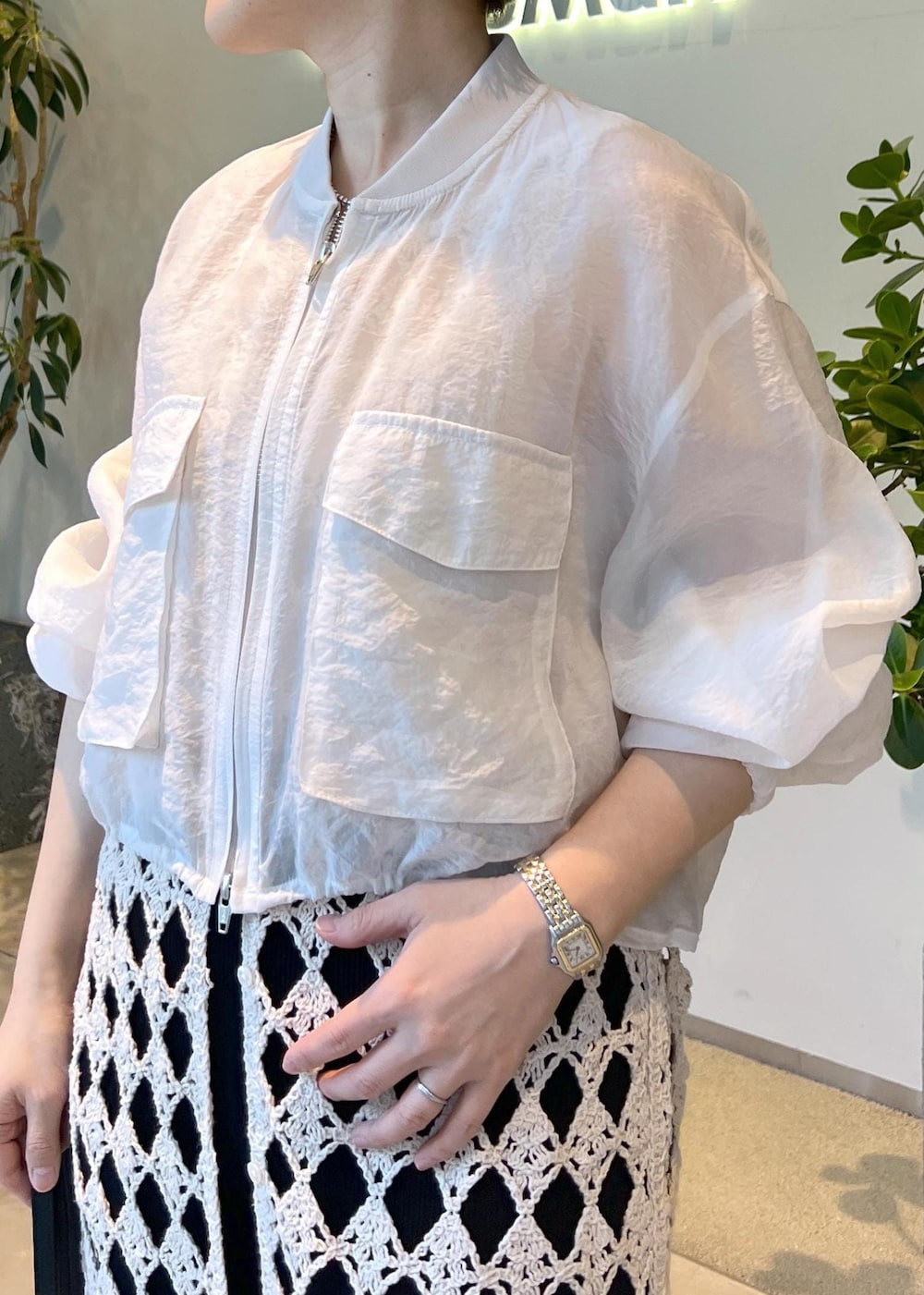 ブラック系のその他パンツ、ホワイト系のワンピース、ホワイト系のブルゾンを着用したレディースの春コーディネートの6枚目の写真