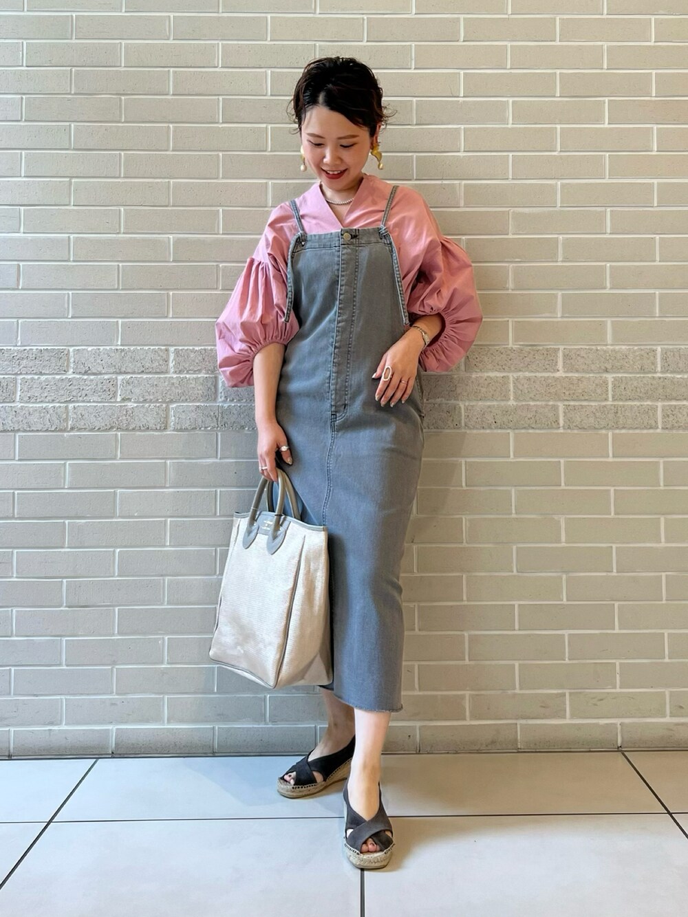 ピンク系のシャツ/ブラウス、グレー系のワンピース、ベージュ系のトートバッグを着用したレディースの春コーディネートの2枚目の写真