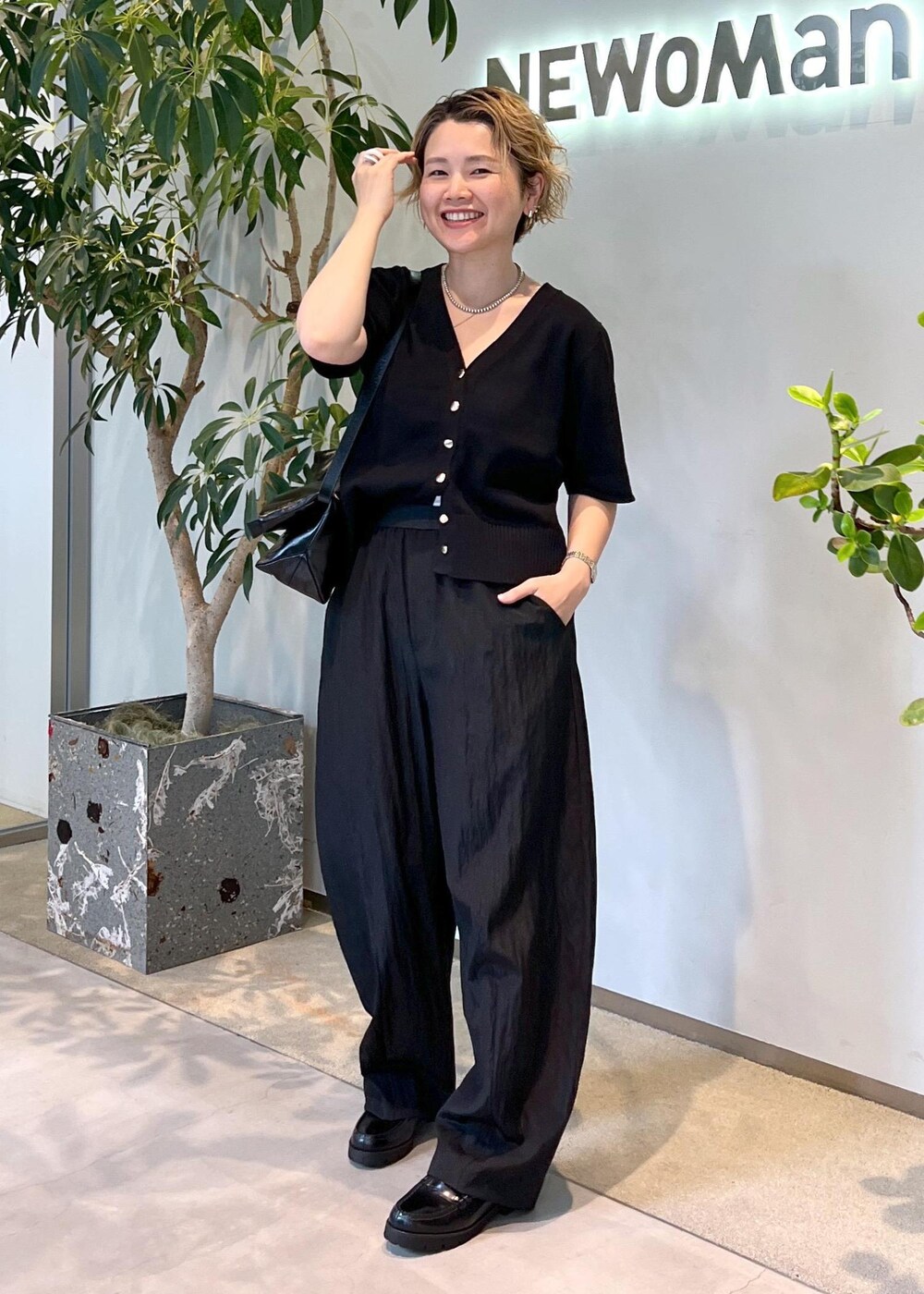 ブラック系のその他パンツ、ブラック系のローファー、ブラック系のショルダーバッグを着用したレディースの夏コーディネートの4枚目の写真