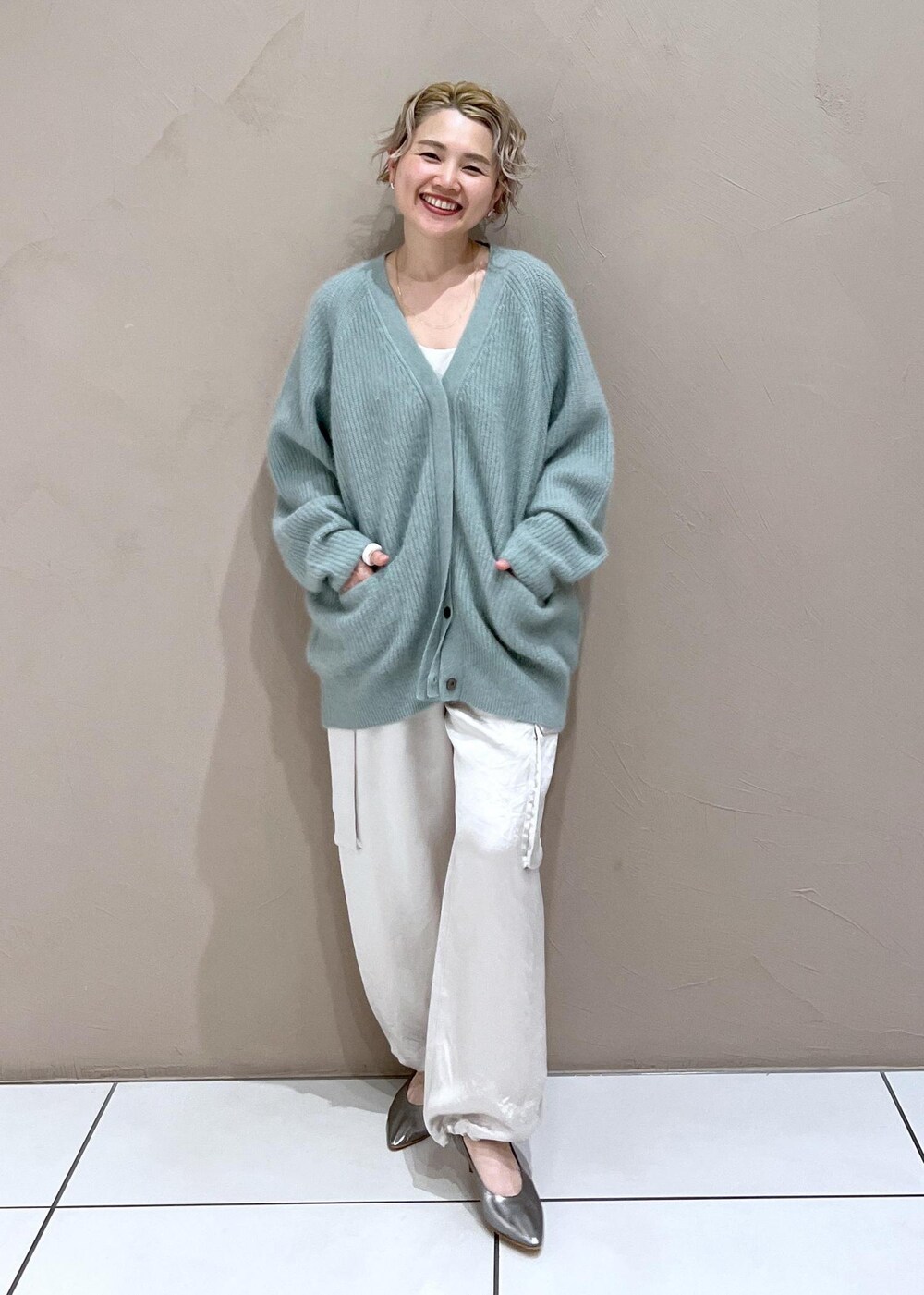 ホワイト系のTシャツ/カットソー、グリーン系のカーディガン/ボレロ、ホワイト系のカーゴパンツを着用したレディースの秋コーディネートの9枚目の写真