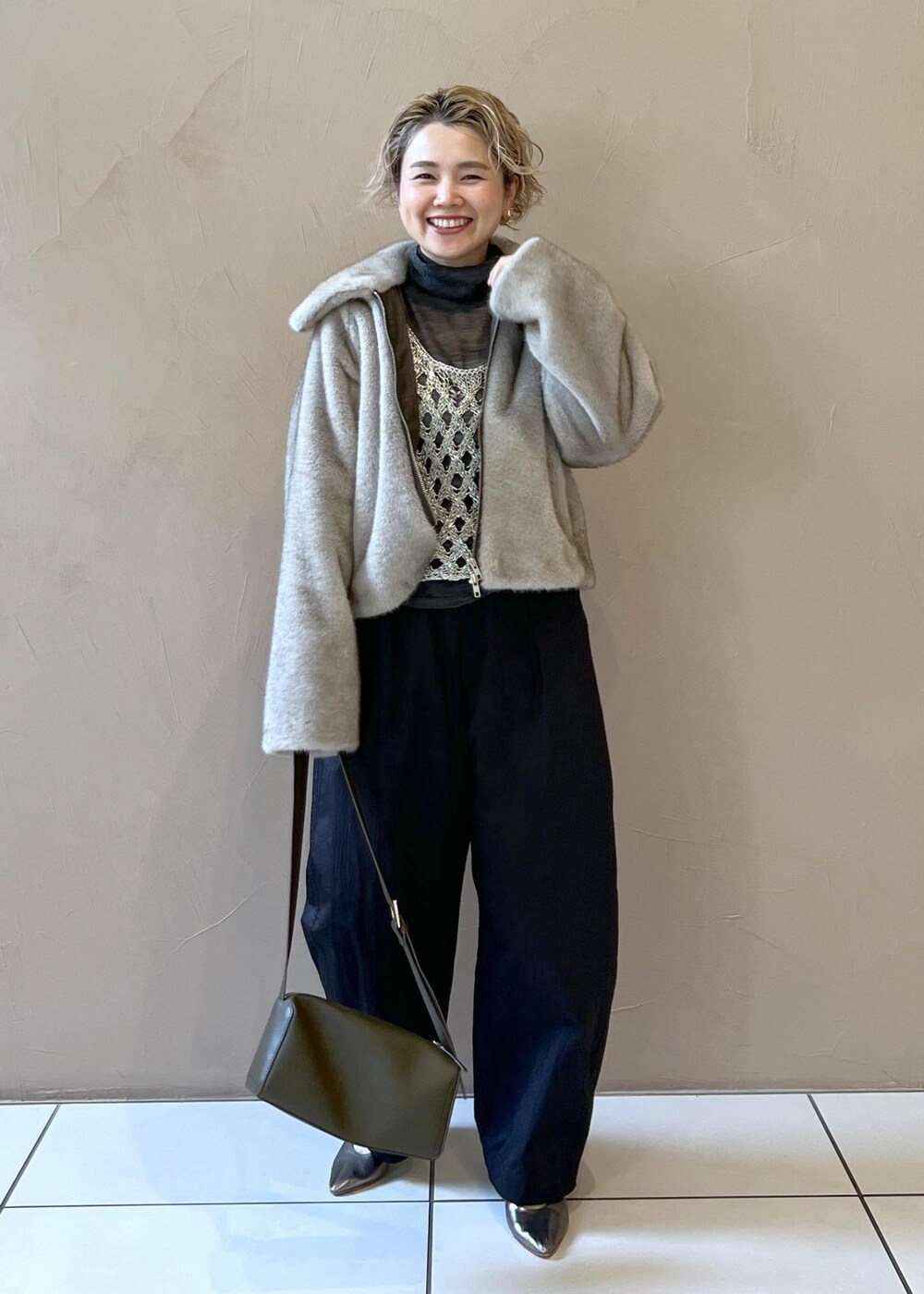 シルバー系のベスト、グレー系のブルゾン、グレー系のニット/セーターを着用したレディースの秋コーディネートの2枚目の写真
