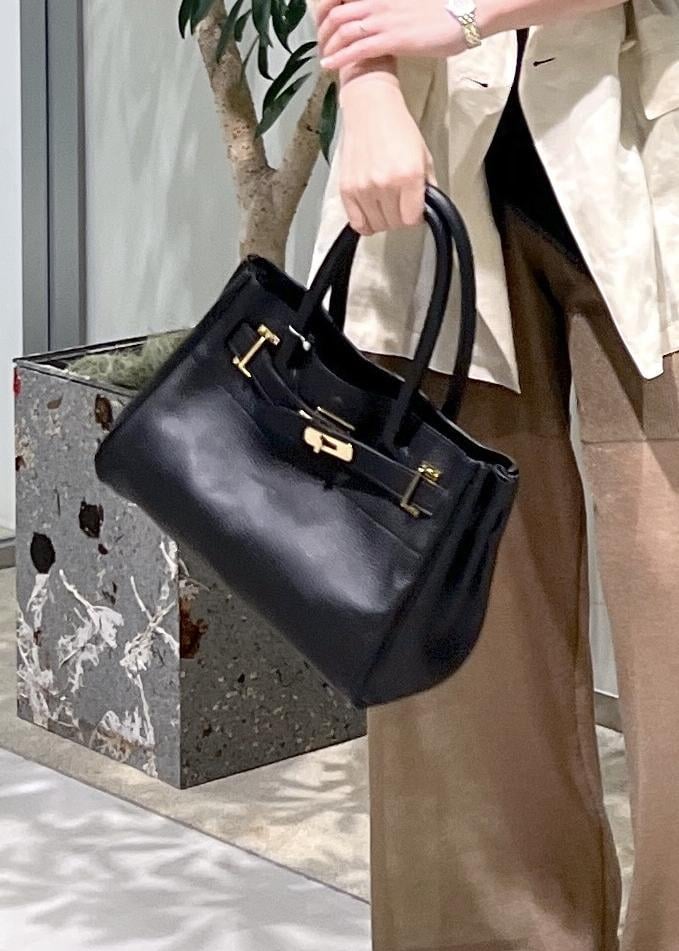 ブラック系のショルダーバッグ、ブラック系のTシャツ/カットソー、ホワイト系のテーラードジャケットを着用したレディースの夏コーディネートの9枚目の写真