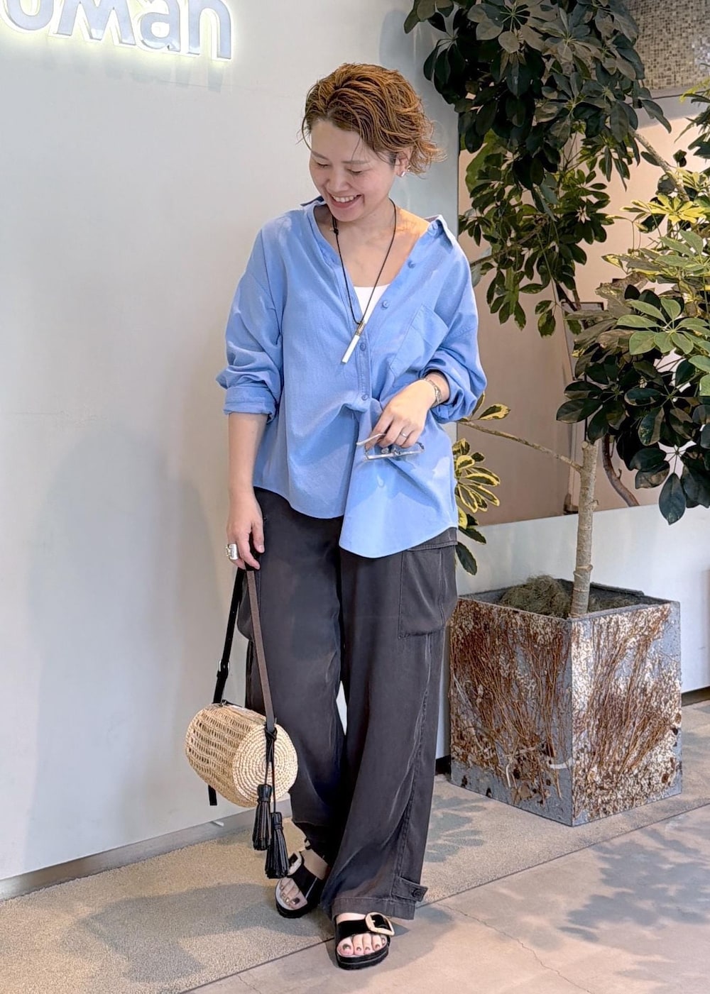 ベージュ系のショルダーバッグ、グレー系のその他パンツ、ブルー系のシャツ/ブラウスを着用したレディースの夏コーディネートの3枚目の写真