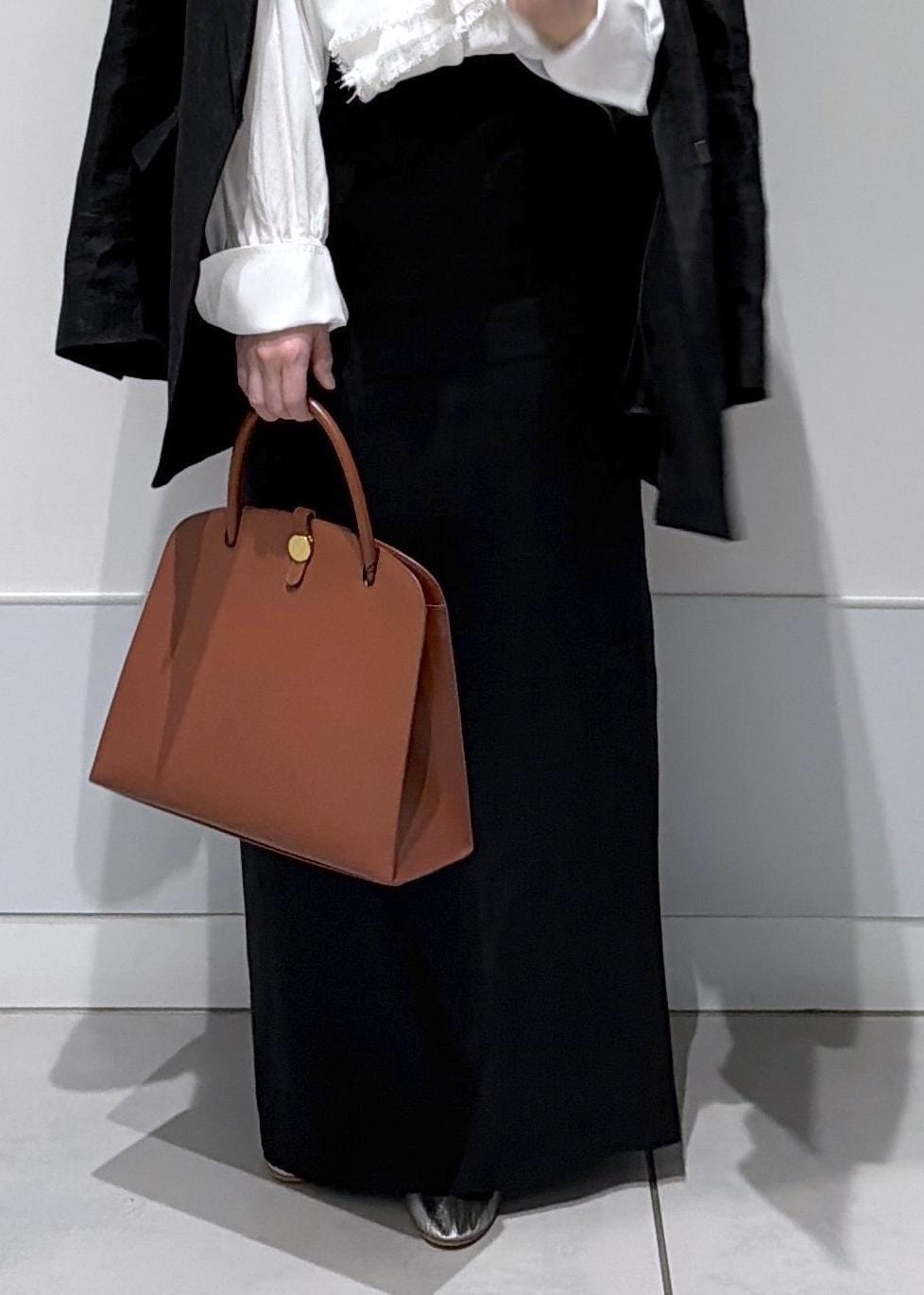 ブラック系のスカート、ブラック系のテーラードジャケット、ホワイト系のシャツ/ブラウスを着用したレディースの冬コーディネートの9枚目の写真