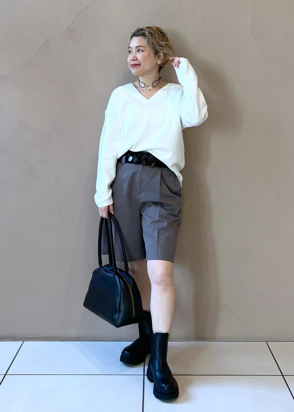 ブラック系のブーツ、ホワイト系のニット/セーター、グレー系のその他パンツを着用したレディースの冬コーディネートの3枚目の写真