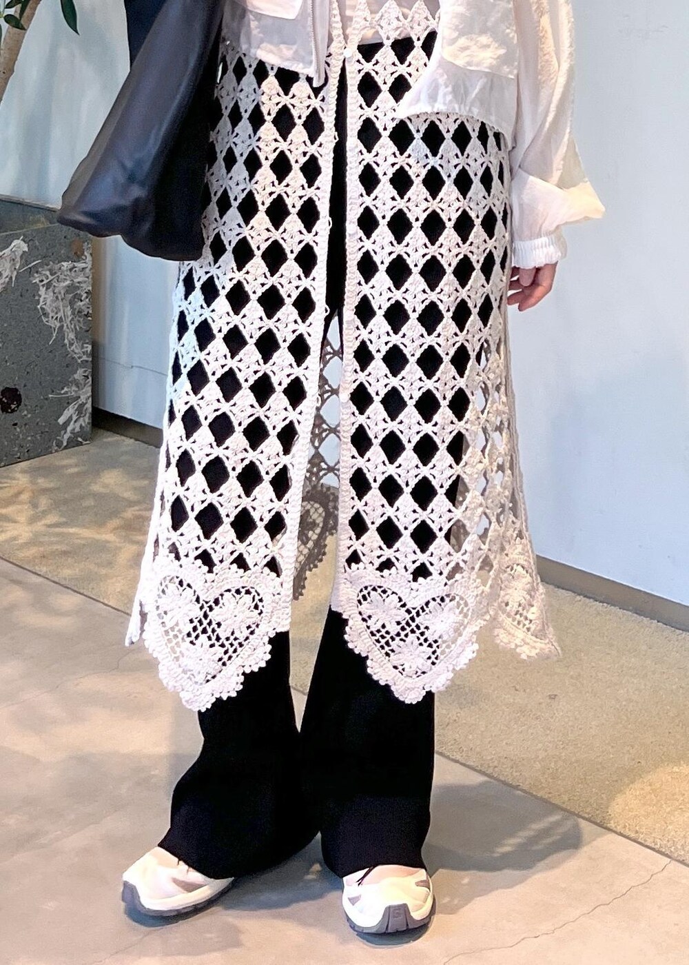 ブラック系のその他パンツ、ホワイト系のワンピース、ホワイト系のブルゾンを着用したレディースの春コーディネートの8枚目の写真