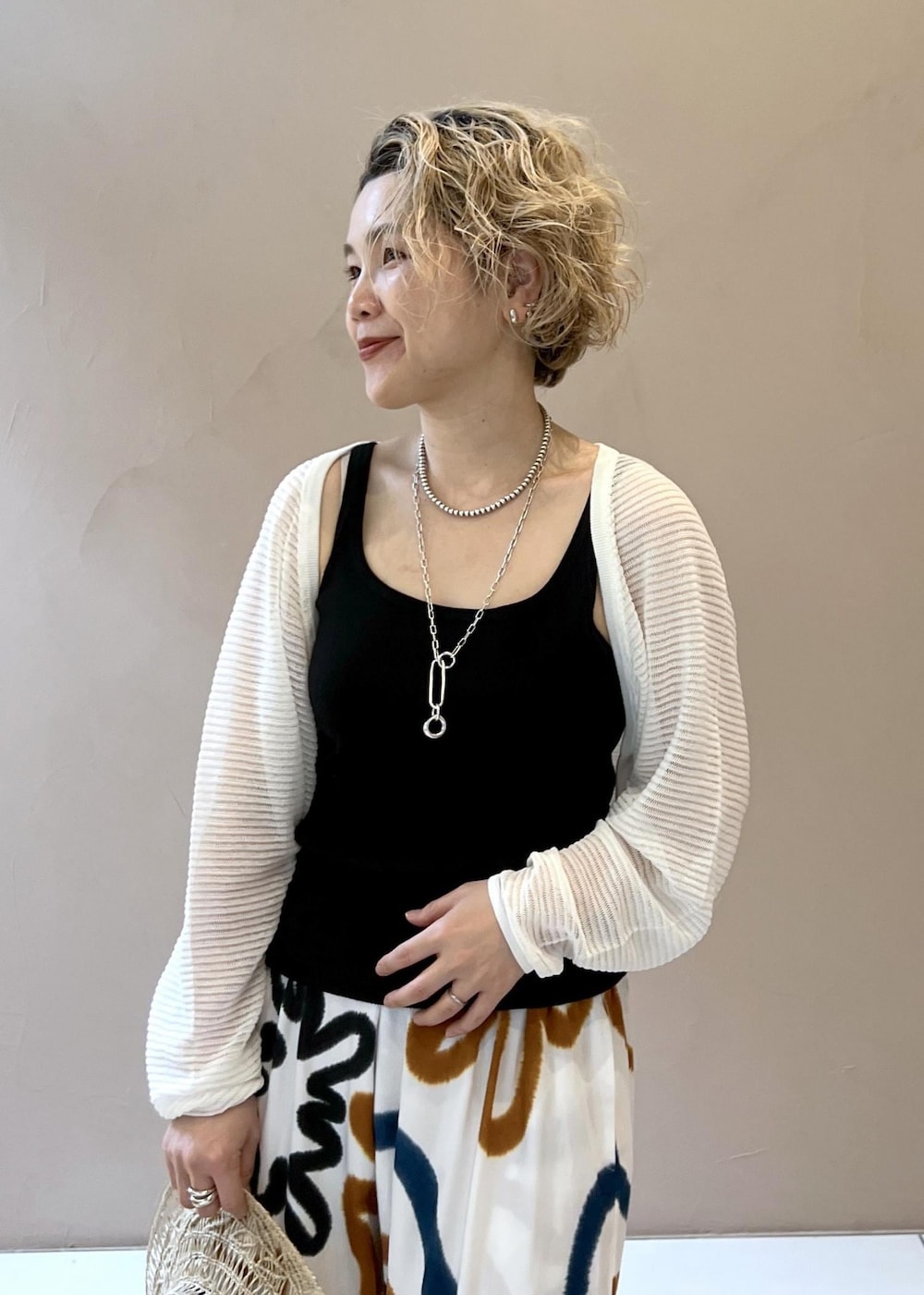 ブラック系のサンダル、ブラック系のタンクトップ、ホワイト系のカーディガン/ボレロを着用したレディースの春コーディネートの7枚目の写真