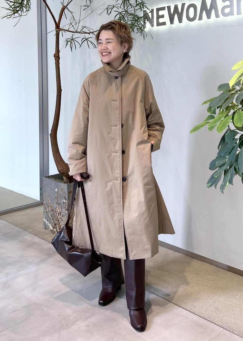 ブラウン系のブーツ、ブラウン系のショルダーバッグ、ベージュ系のダウンジャケット/コートを着用したレディースの秋コーディネートの5枚目の写真