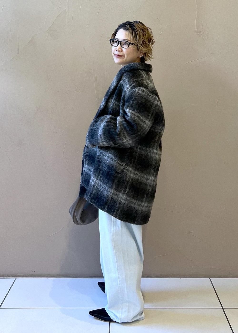 ブルー系のデニムパンツ、グレー系のその他アウター、グレー系のハンドバッグを着用したレディースの秋コーディネートの6枚目の写真