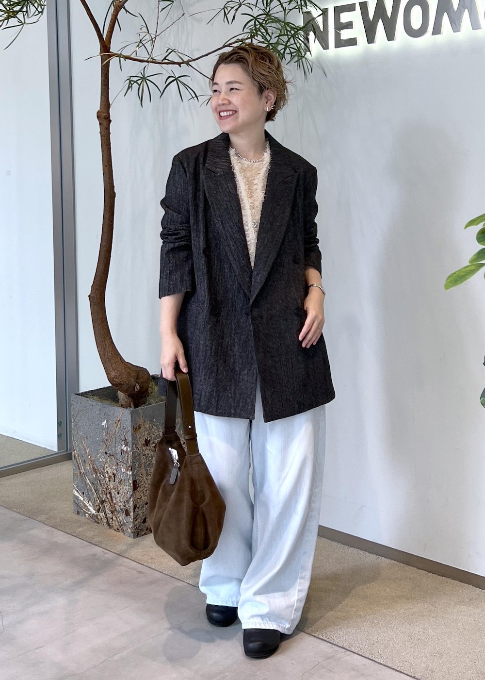 ブルー系のデニムパンツ、ベージュ系のその他トップス、ブラック系のテーラードジャケットを着用したレディースの秋コーディネートの5枚目の写真