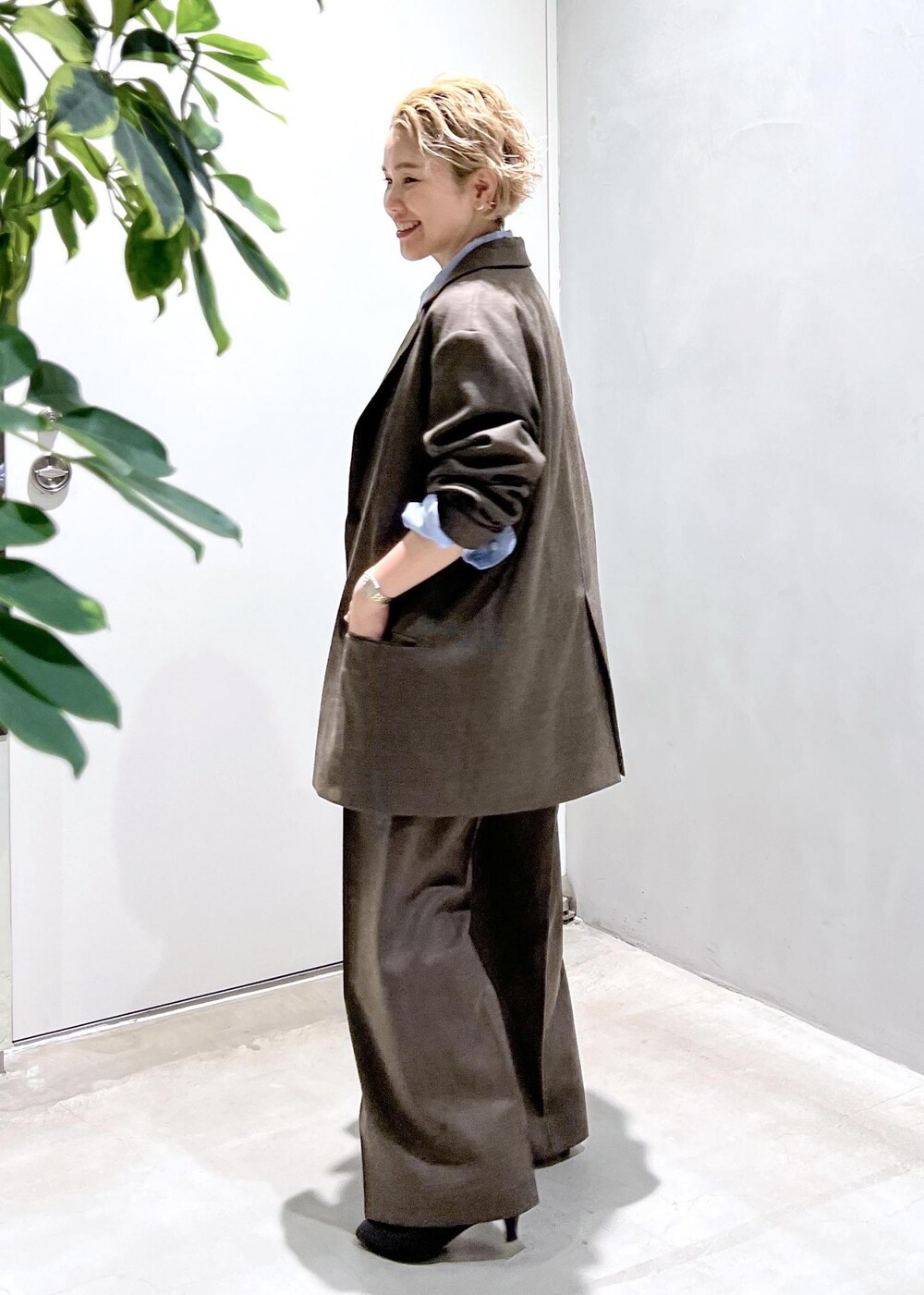 ブルー系のシャツ/ブラウス、ブラック系のショルダーバッグ、ブラウン系のスラックスを着用したレディースの秋コーディネートの4枚目の写真