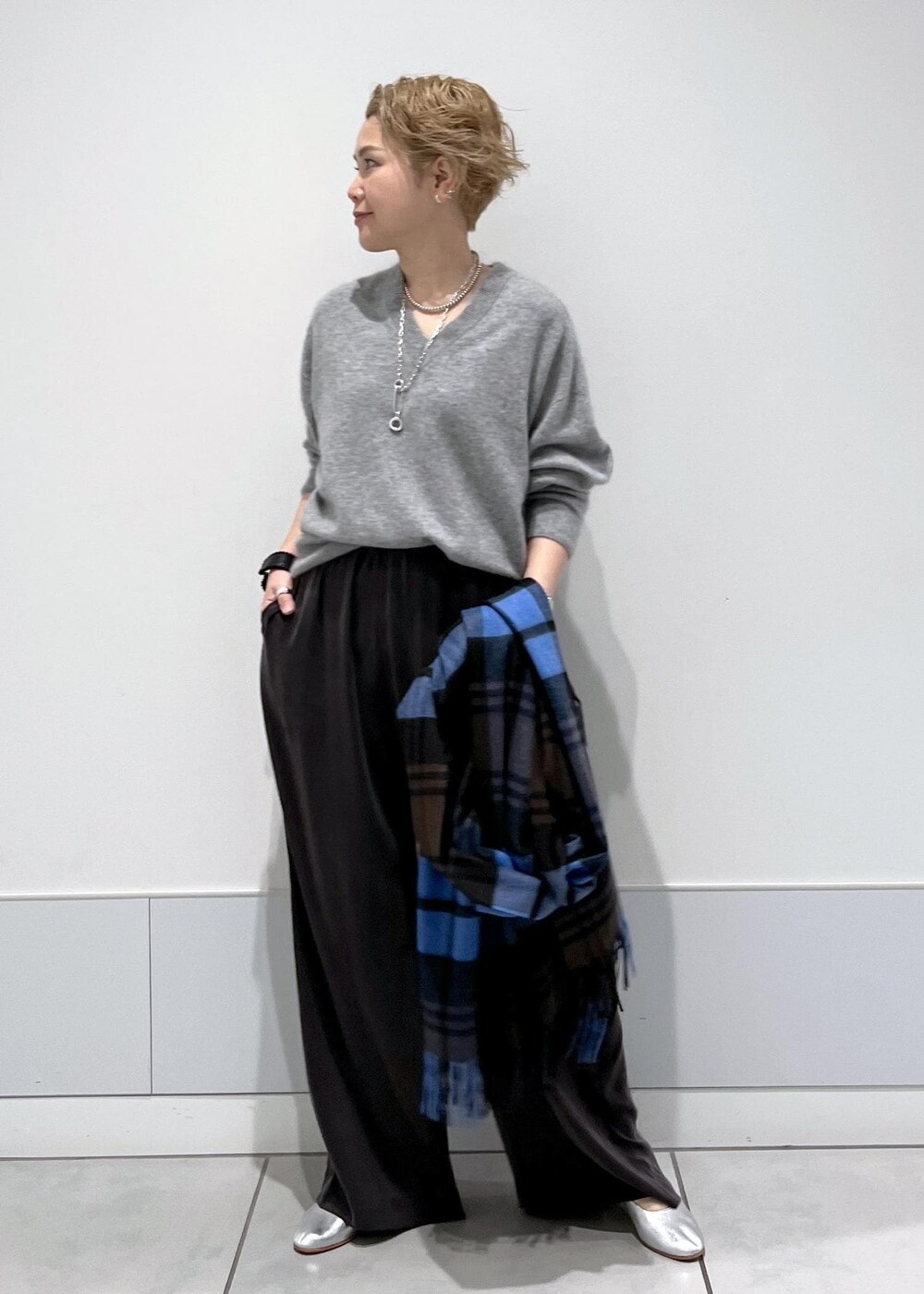 グレー系のその他パンツ、シルバー系のパンプス、その他のネックレスを着用したレディースの秋コーディネートの5枚目の写真