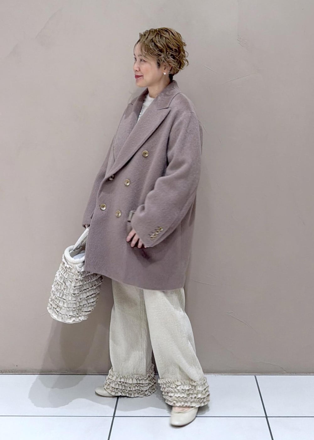 ベージュ系のパンプス、ブラウン系のチェスターコートを着用したレディースの冬コーディネートの5枚目の写真