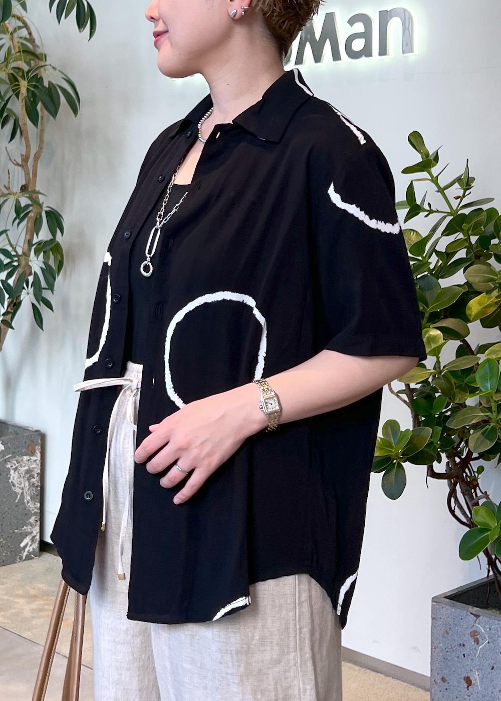 ブラウン系のボストンバッグ、ホワイト系のその他パンツ、ブラック系のサンダルを着用したレディースの夏コーディネートの6枚目の写真