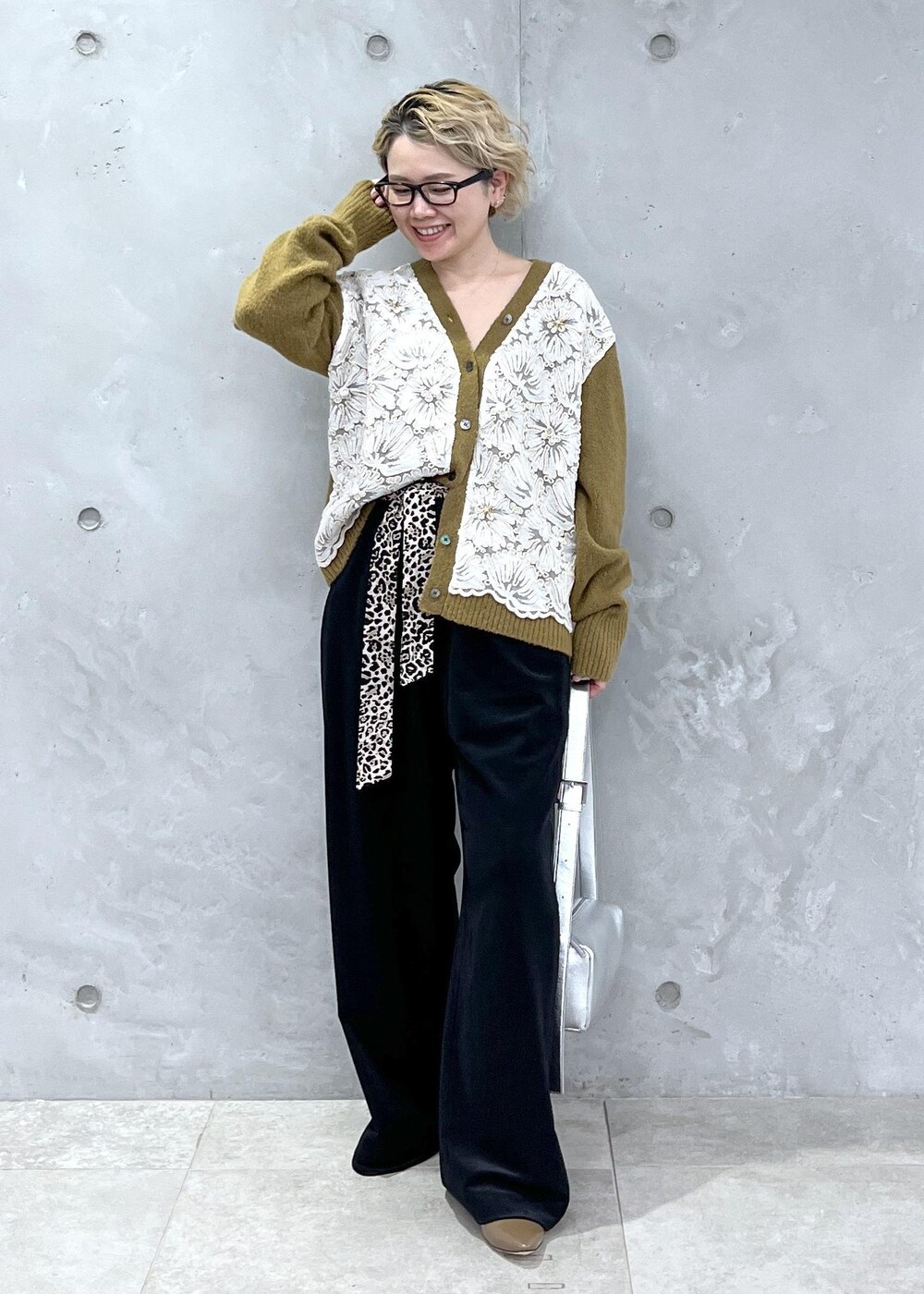 イエロー系のカーディガン/ボレロ、シルバー系のショルダーバッグ、ブラック系のその他パンツを着用したレディースの冬コーディネートの2枚目の写真