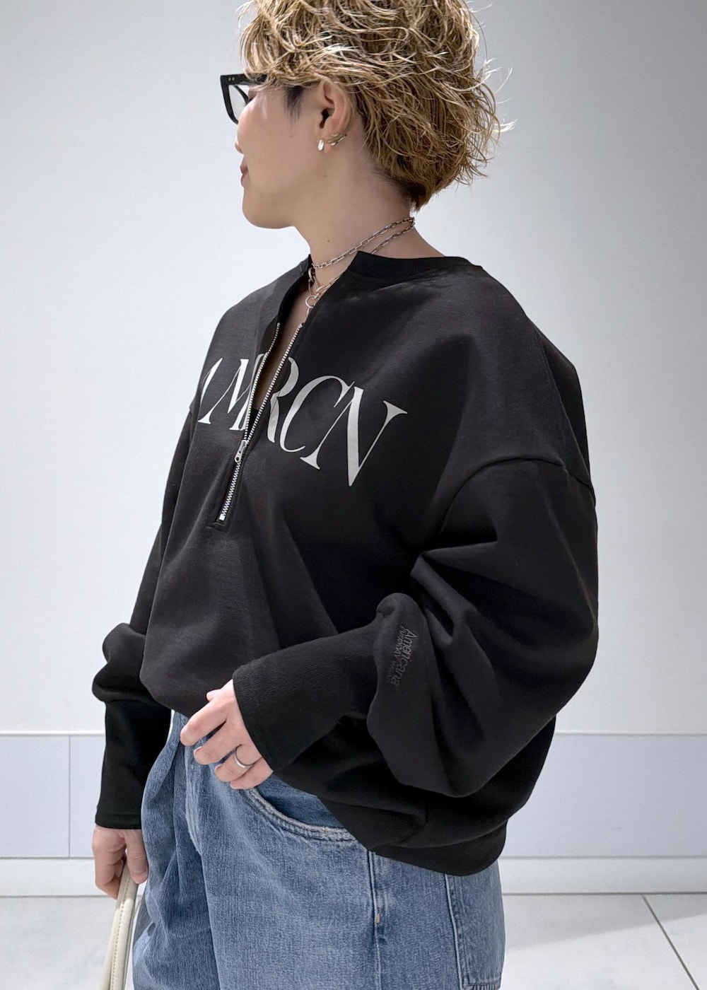 ブラック系のスウェット、ブルー系のデニムパンツを着用したレディースの冬コーディネートの5枚目の写真