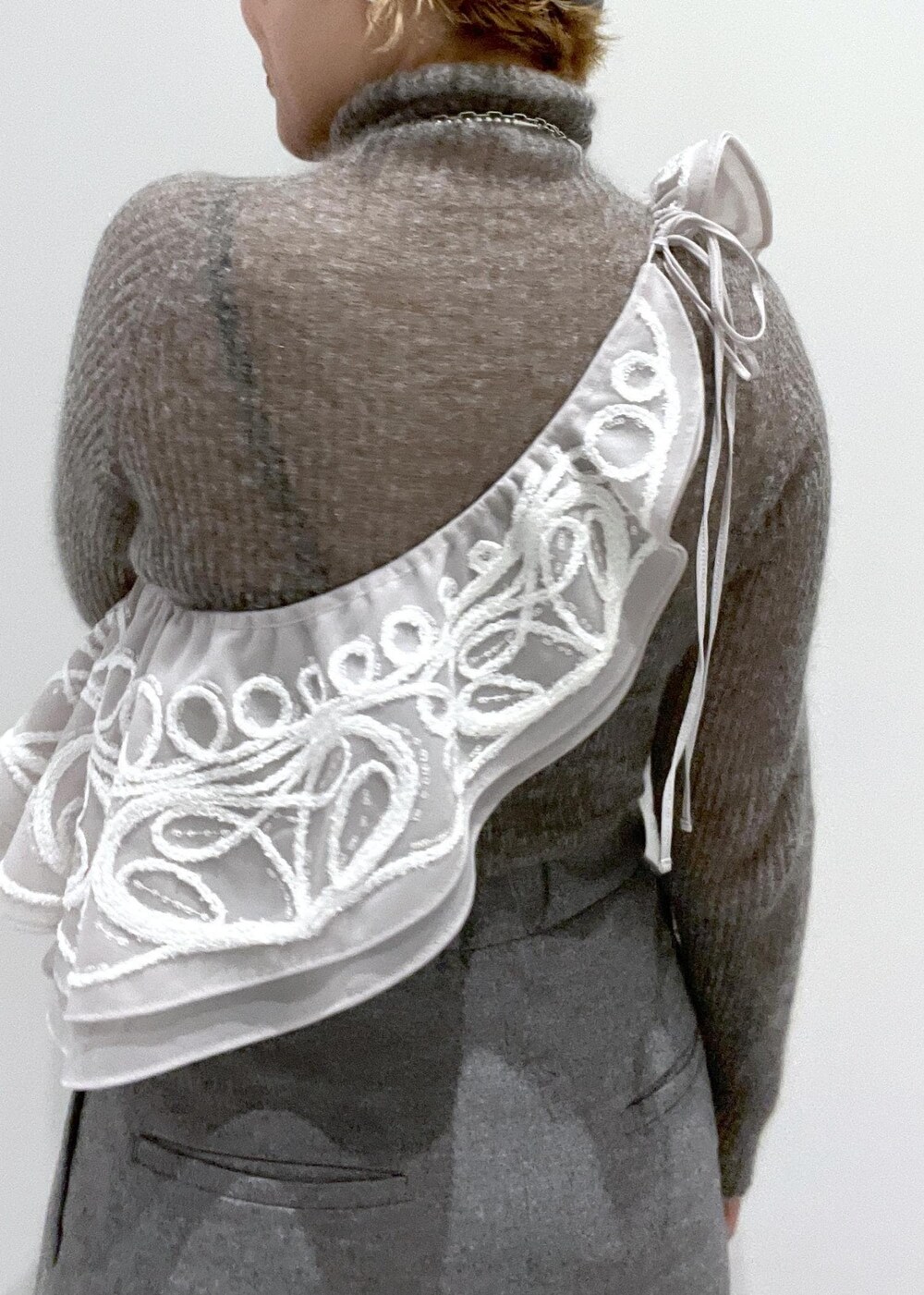 ブラック系のブーツ、グレー系のニット/セーター、ベージュ系のストール/ショールを着用したレディースの冬コーディネートの6枚目の写真