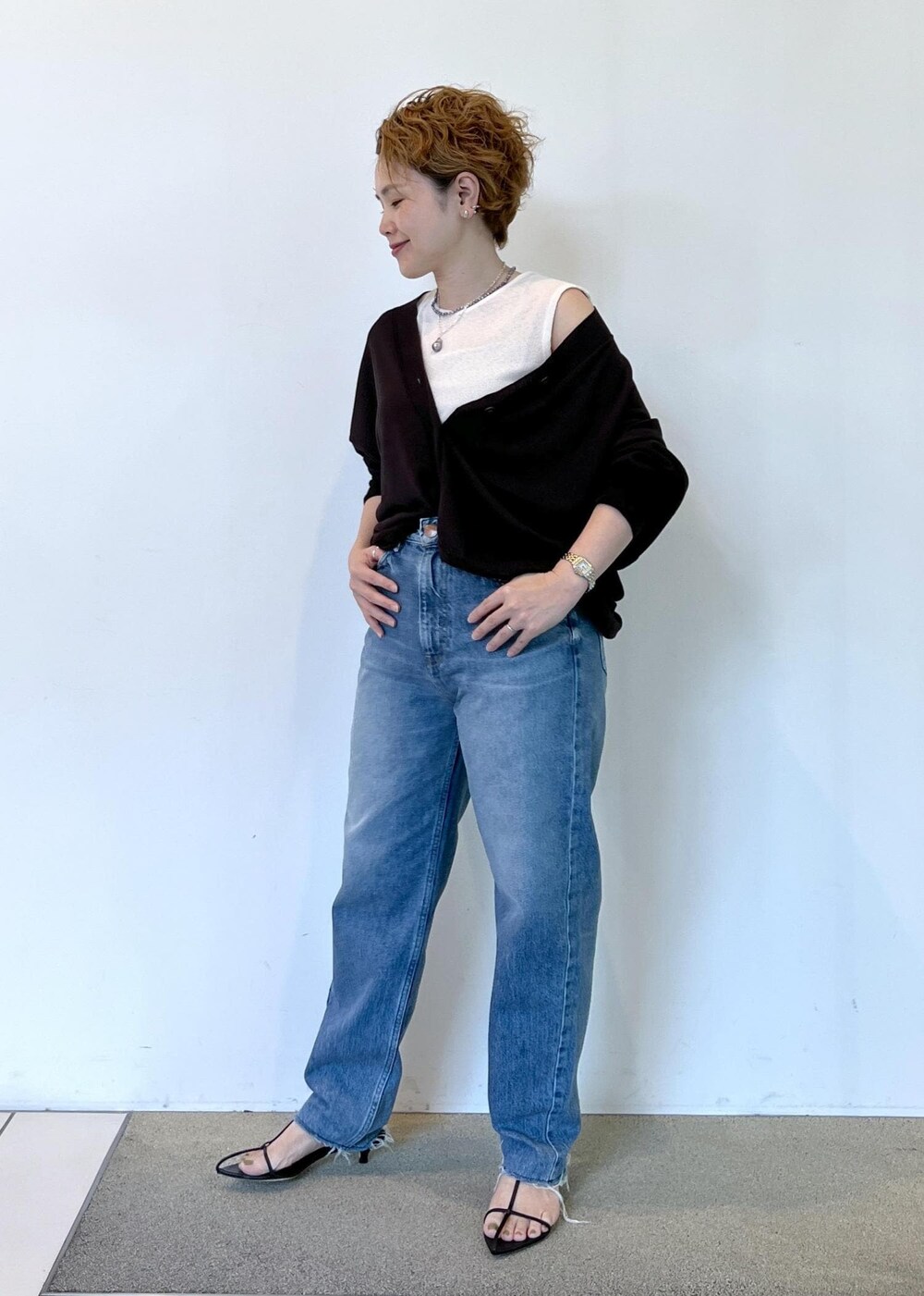ブラック系のサンダル、ブラウン系のカーディガン/ボレロ、ブルー系のデニムパンツを着用したレディースの夏コーディネートの3枚目の写真