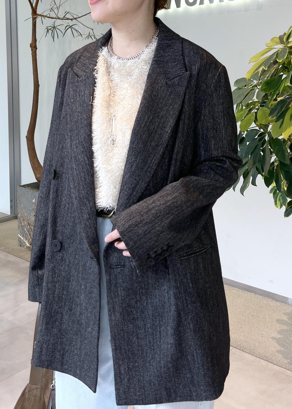 ブルー系のデニムパンツ、ベージュ系のその他トップス、ブラック系のテーラードジャケットを着用したレディースの秋コーディネートの7枚目の写真