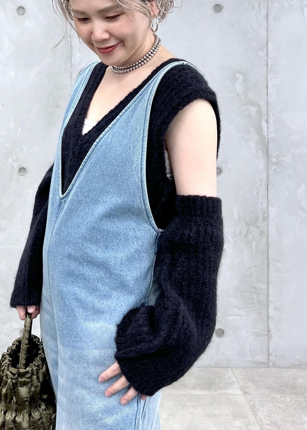 ブラック系のベスト、グリーン系のショルダーバッグ、ブルー系のサロペット/オーバーオールを着用したレディースの夏コーディネートの6枚目の写真