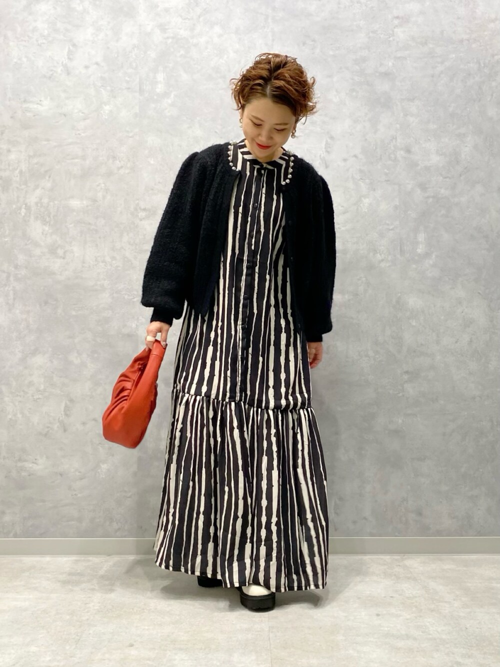 ブラック系のカーディガン/ボレロ、レッド系のハンドバッグ、ホワイト系のブーツを着用したレディースの秋コーディネートの4枚目の写真