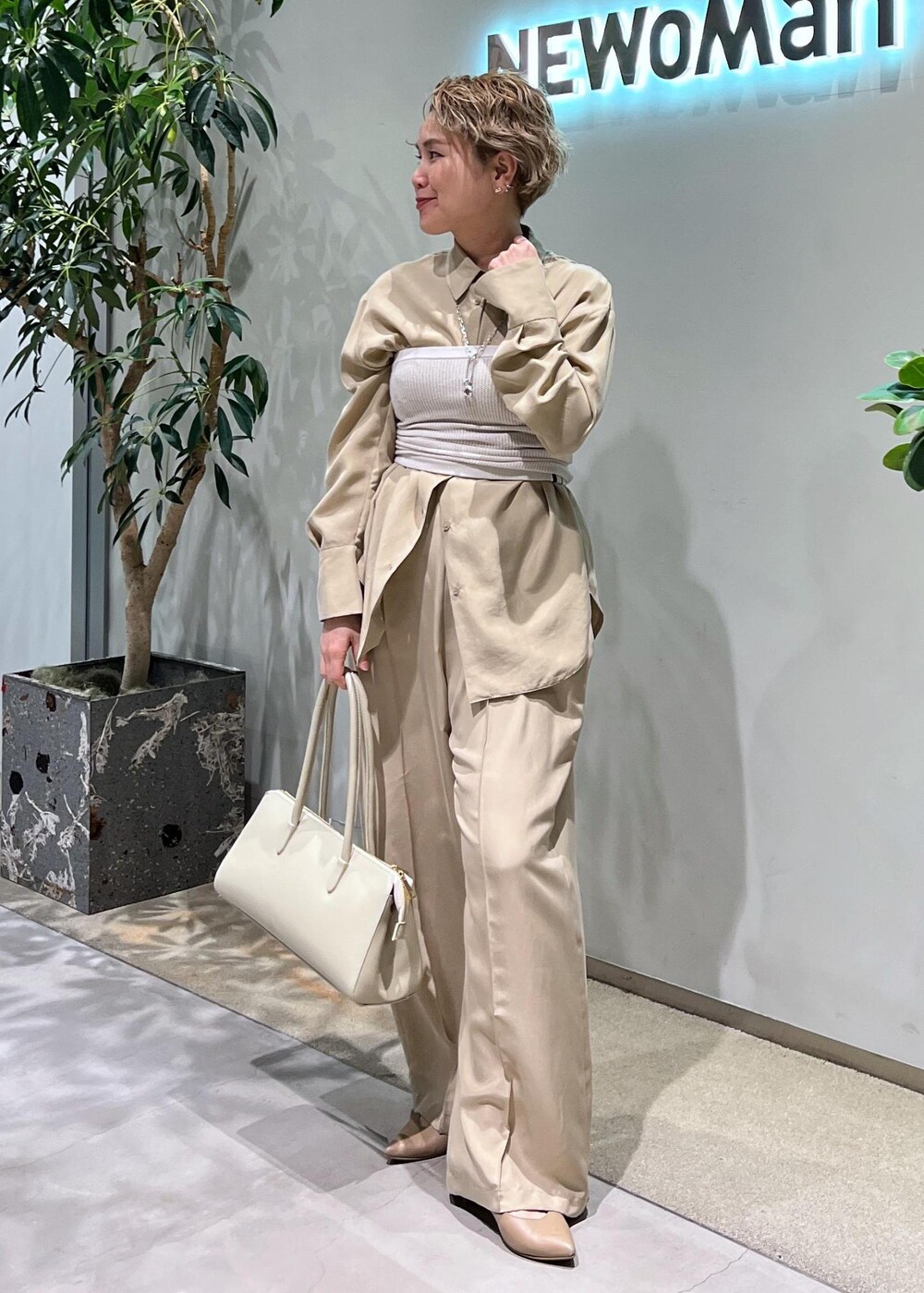 ベージュ系のその他パンツ、ベージュ系のシャツ/ブラウス、ホワイト系のボストンバッグを着用したレディースの春コーディネートの2枚目の写真