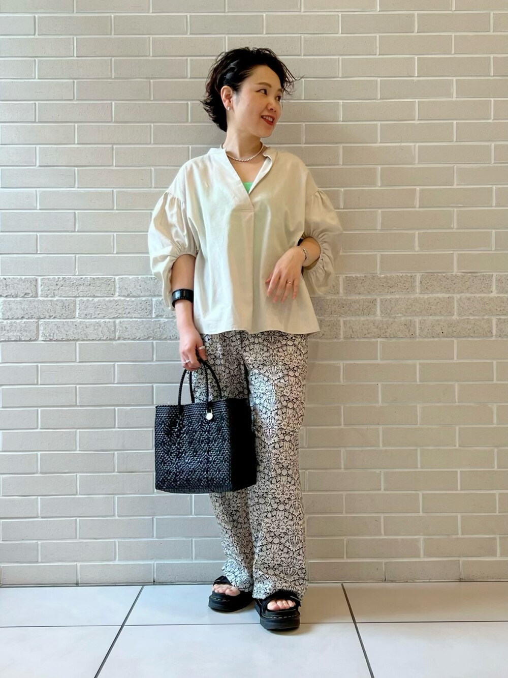 ベージュ系のシャツ/ブラウス、ブラック系のその他パンツ、ブラック系のトートバッグを着用したレディースの春コーディネートの2枚目の写真