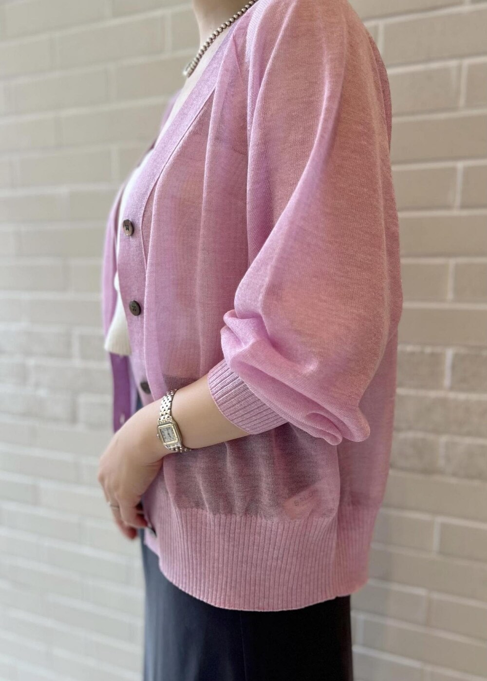 グレー系のスカート、ピンク系のカーディガン/ボレロ、ホワイト系のチューブトップを着用したレディースの春コーディネートの6枚目の写真