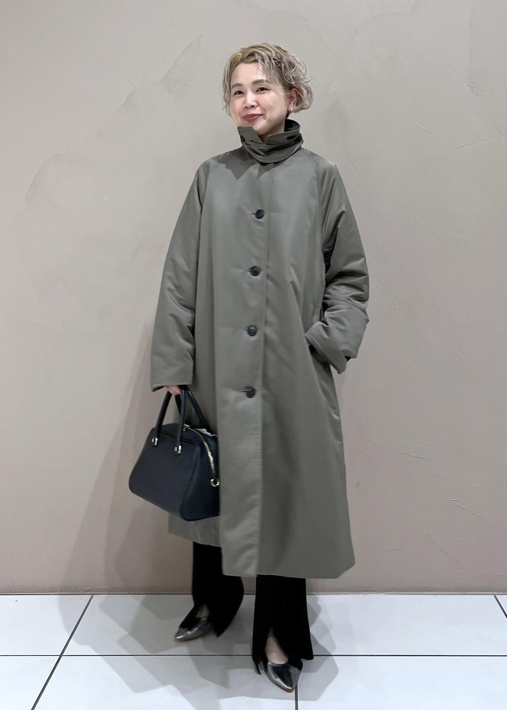 ブラック系のボストンバッグ、グリーン系のダウンジャケット/コート、ブラック系のその他パンツを着用したレディースの秋コーディネートの3枚目の写真