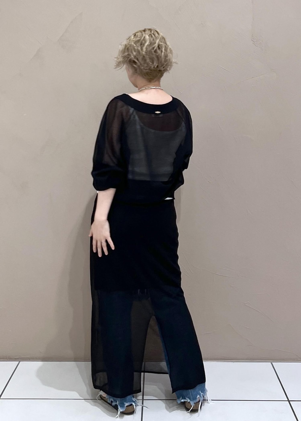 ホワイト系のタンクトップ、ブラック系のカーディガン/ボレロ、ブルー系のデニムパンツを着用したレディースの夏コーディネートの5枚目の写真