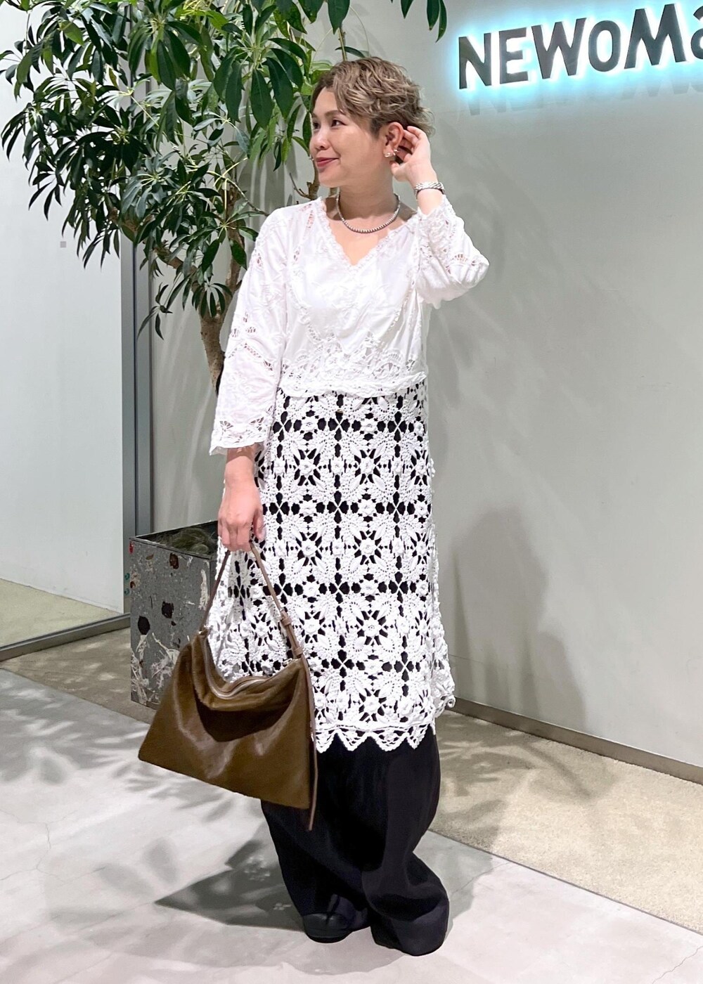 ブラック系のスラックス、ブルー系のシャツ/ブラウス、ブラウン系のショルダーバッグを着用したレディースの夏コーディネートの5枚目の写真