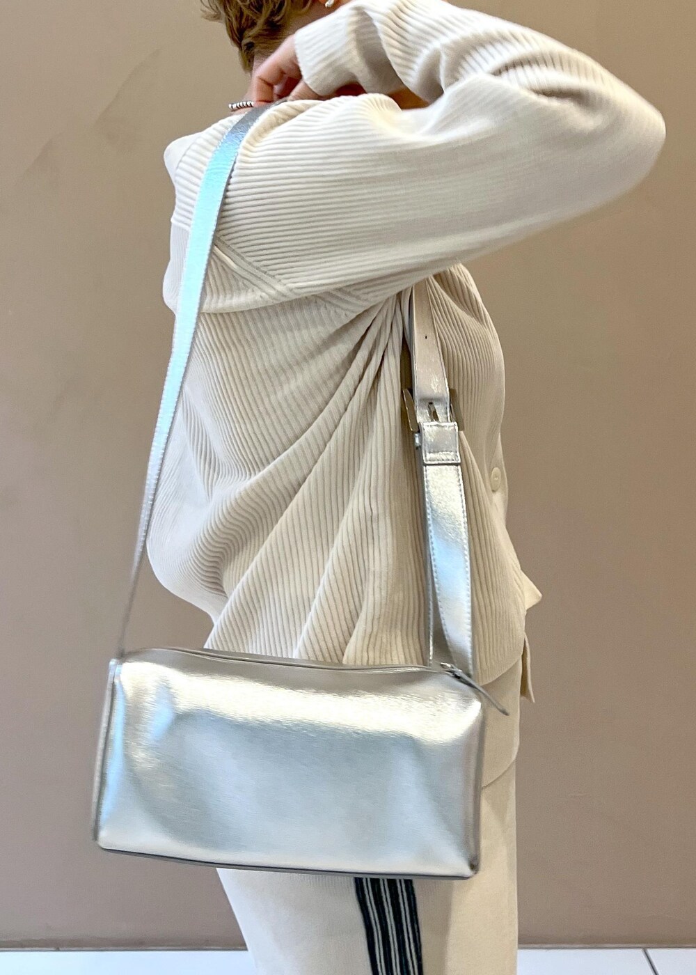 シルバー系のショルダーバッグ、ホワイト系のカーディガン/ボレロ、ホワイト系のその他パンツを着用したレディースの冬コーディネートの8枚目の写真