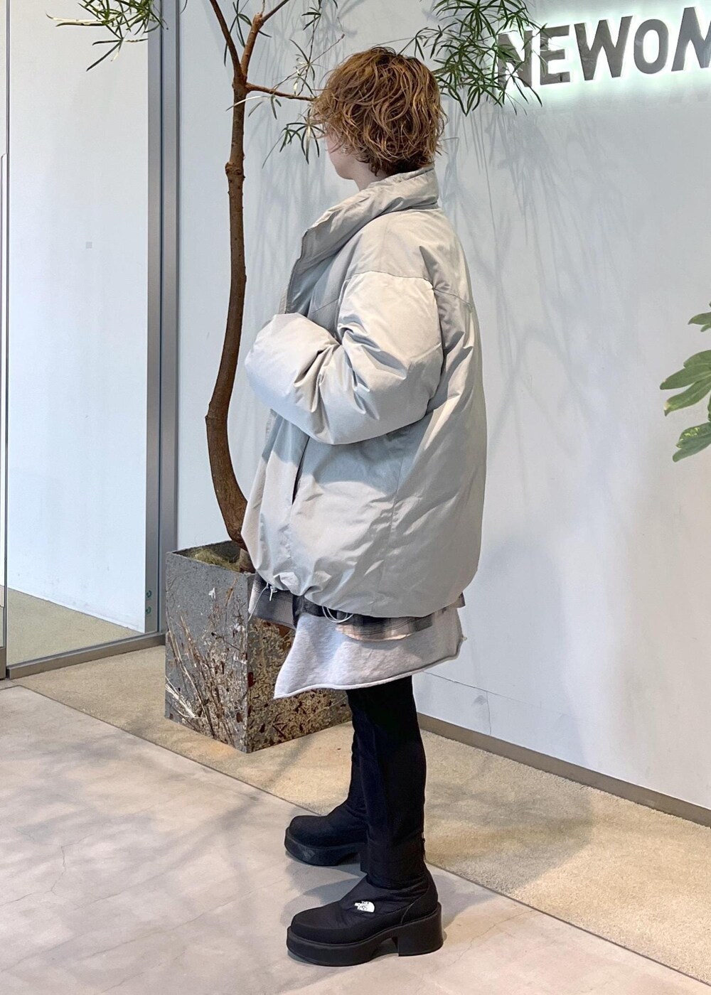 グリーン系のダウンジャケット/コート、ブラウン系のハンドバッグ、ブラック系のブーツを着用したレディースの秋コーディネートの5枚目の写真