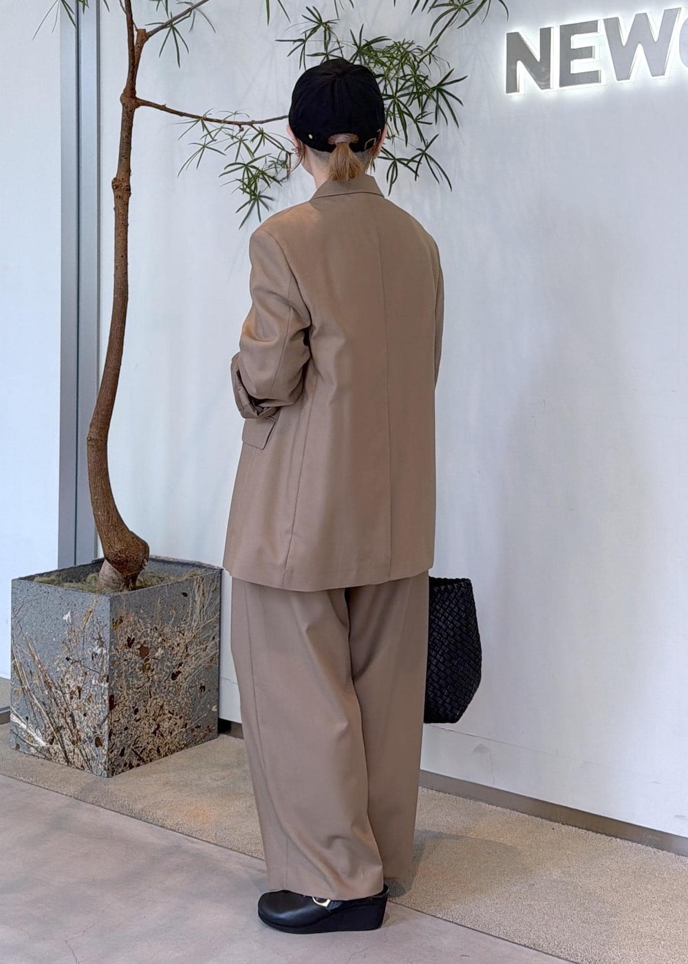 ベージュ系のその他パンツ、ベージュ系のテーラードジャケット、ブラック系のトートバッグを着用したレディースの秋コーディネートの6枚目の写真