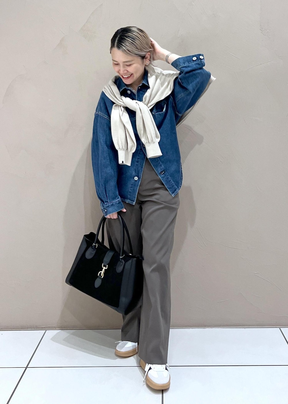 ブラウン系のその他パンツ、ブラック系のハンドバッグ、ホワイト系のスニーカーを着用したレディースの夏コーディネートの3枚目の写真