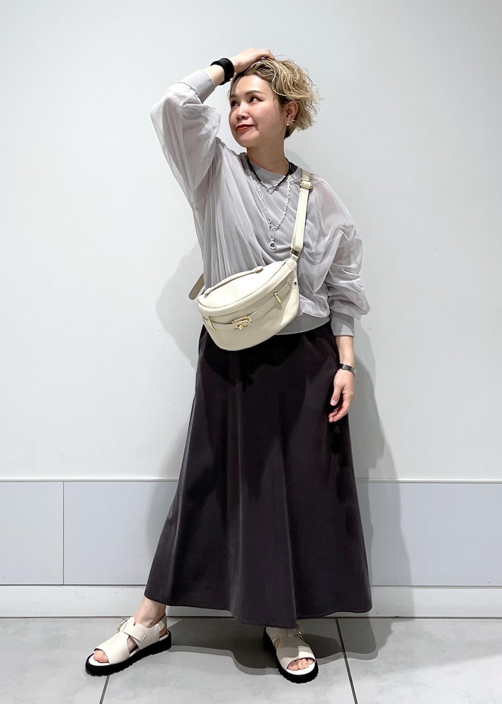 ホワイト系のサンダル、ベージュ系のボディバッグ/ウエストポーチ、グレー系のワンピースを着用したレディースの春コーディネートの2枚目の写真