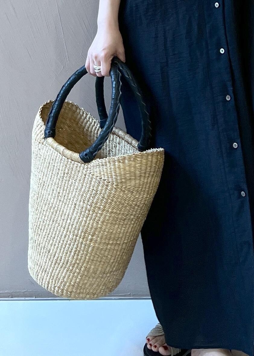 ゴールド系のサンダル、ブラック系のワンピース、ベージュ系のかごバッグを着用したレディースの夏コーディネートの8枚目の写真