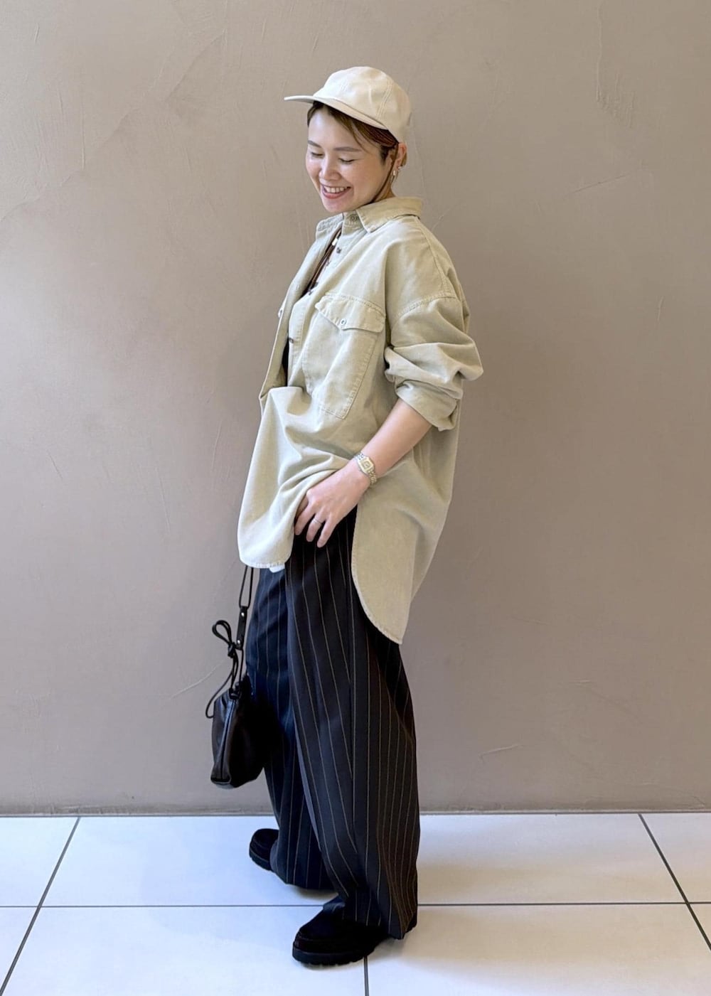 グレー系のその他パンツ、ブラウン系のショルダーバッグ、ブラウン系のローファーを着用したレディースの夏コーディネートの4枚目の写真