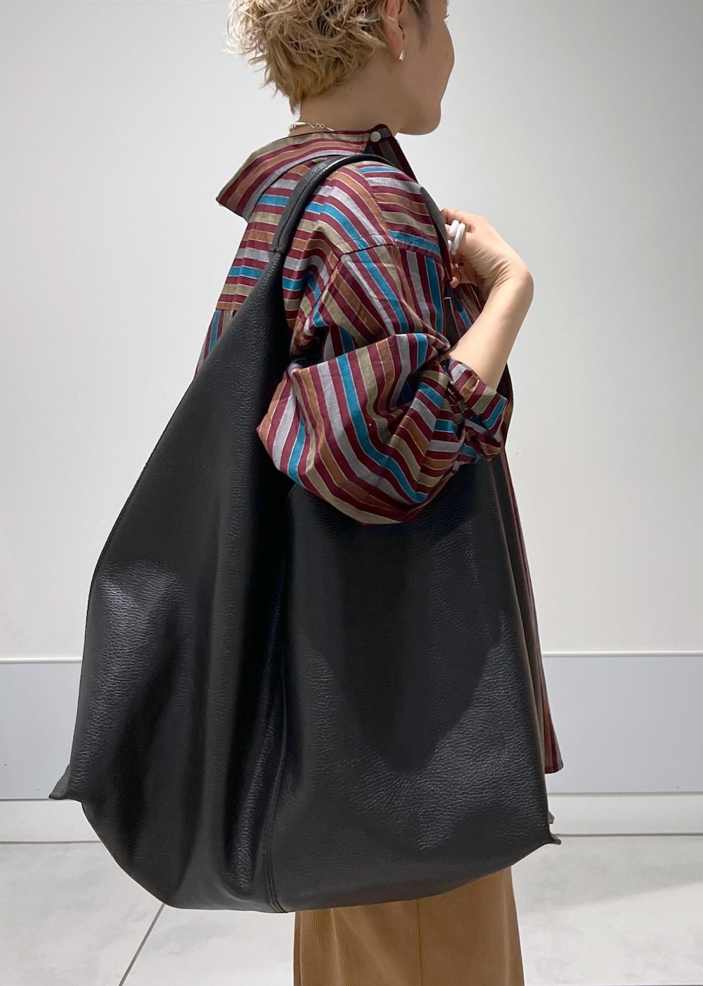 ブラック系のトートバッグ、ブラック系のスニーカー、ブラウン系のその他パンツを着用したレディースの冬コーディネートの8枚目の写真