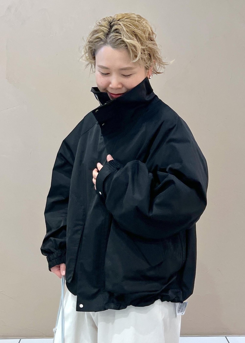 ブラック系のブルゾン、ホワイト系のその他パンツ、シルバー系のショルダーバッグを着用したレディースの春コーディネートの6枚目の写真