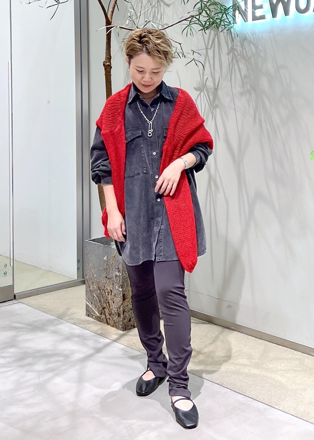 グレー系のシャツ/ブラウス、ブラック系のパンプス、レッド系のニット/セーターを着用したレディースの秋コーディネートの3枚目の写真