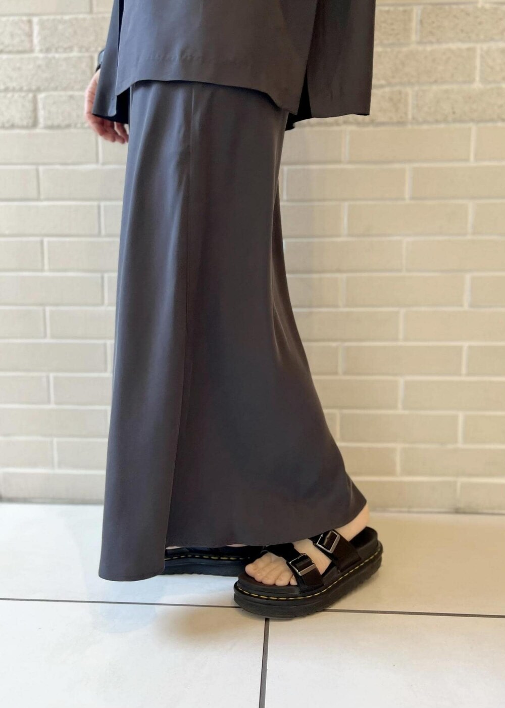 グレー系のスカート、ピンク系のカーディガン/ボレロ、ホワイト系のチューブトップを着用したレディースの春コーディネートの7枚目の写真