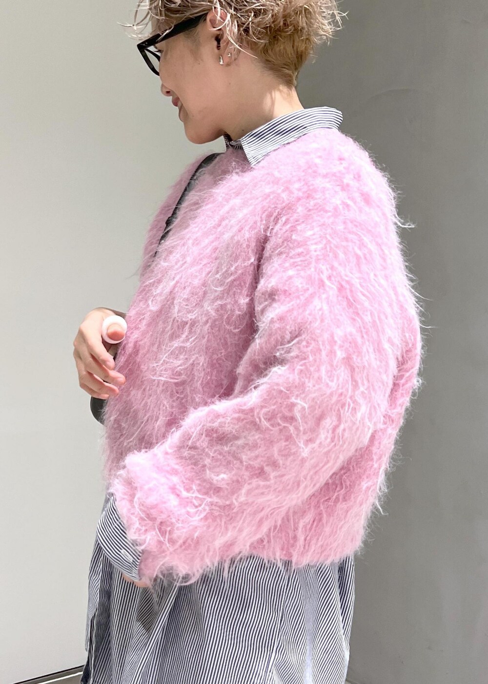 ブラック系のブーツ、ピンク系のニット/セーター、ブラック系のデニムパンツを着用したレディースの秋コーディネートの6枚目の写真